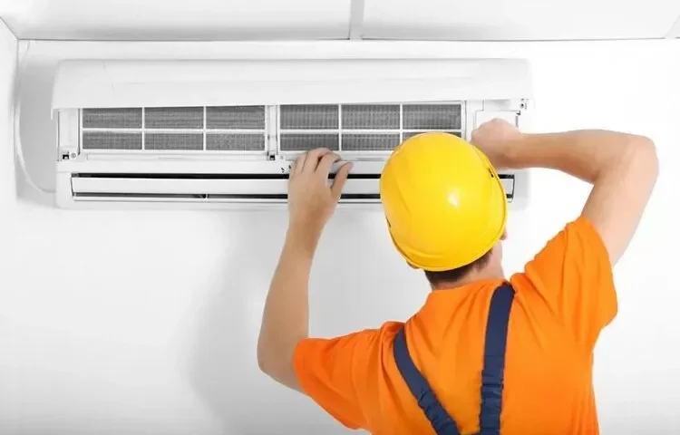 Technician performing AC maintenance, following an AC maintenance checklist to ensure efficient cooling and system longevity