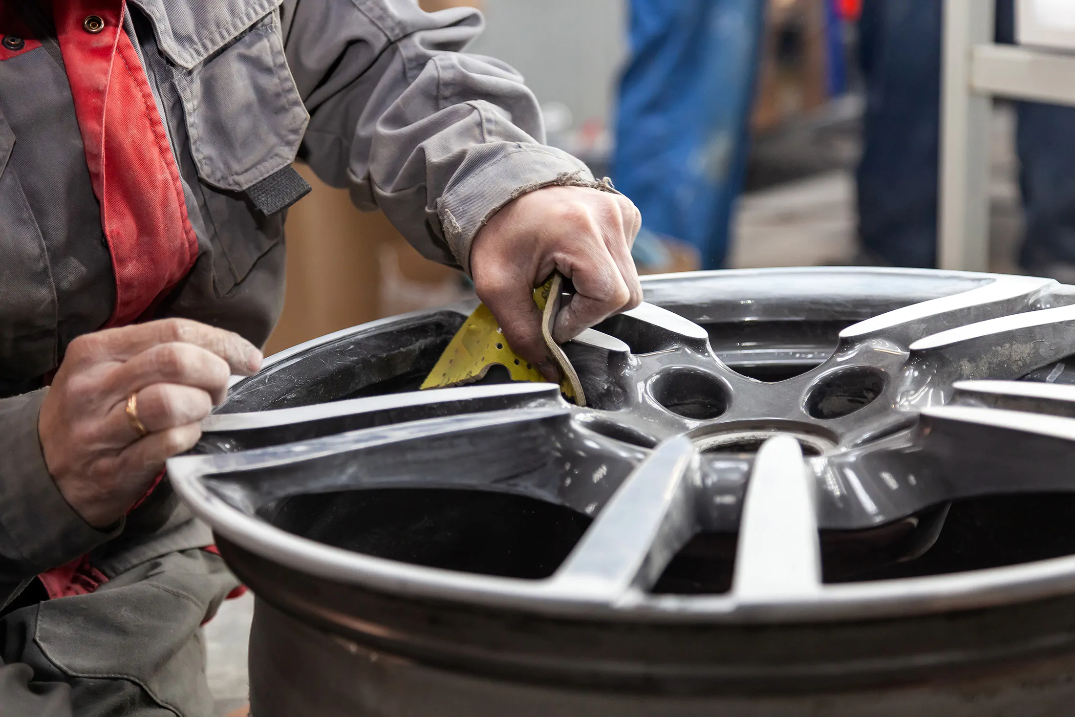 man-refurbishing-alloy-wheel